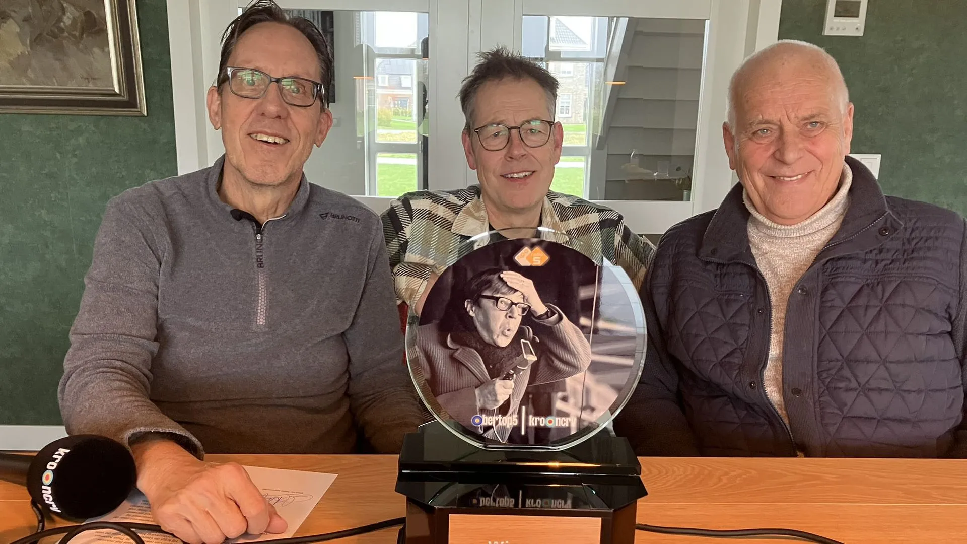 Gio Lippens geflankeerd door Bert Kranenbarg en Evert ten Napel na de ontvangst van de Theo Koomen Oeuvre Award. FOTO BertOp5/NOS.