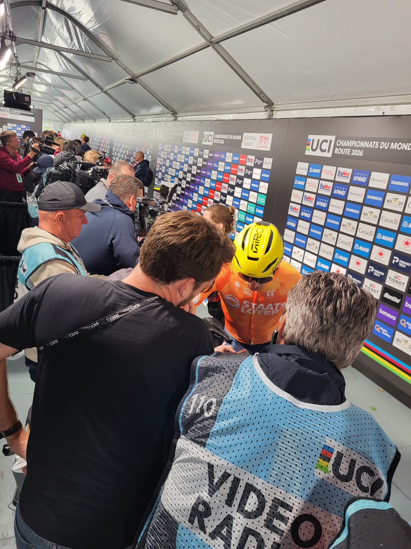 Journalisten dringen rond een renner in de mixed zone van het WK in Montréal